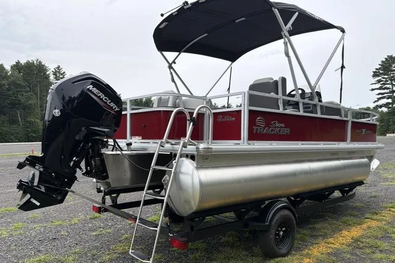 Slide: The Image of 2026 Sun Tracker Bass Buggy 18 DLX pontoon boat with Mercury outboard motor on trailer. - 5