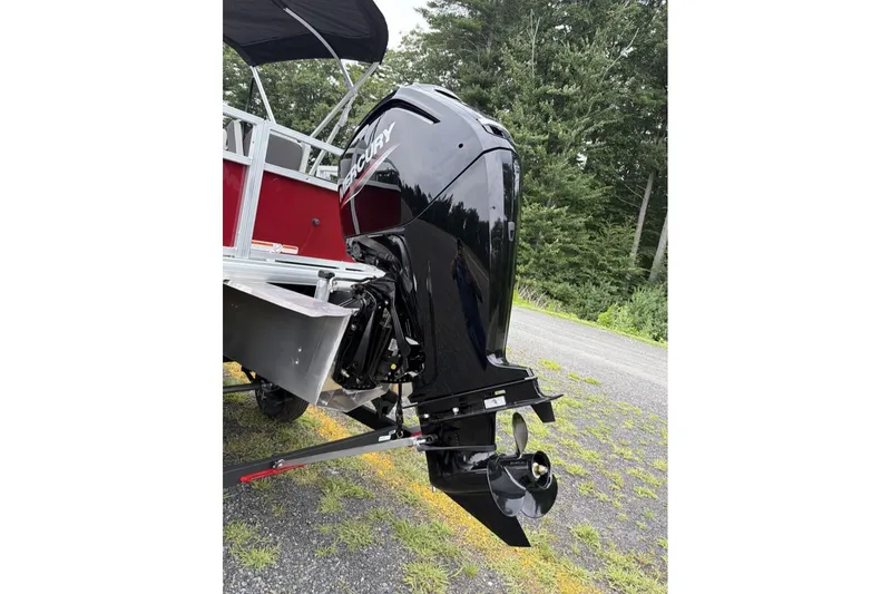 Slide: The Image of 2026 Sun Tracker Bass Buggy 18 DLX with Mercury outboard motor, parked on grass. - 11