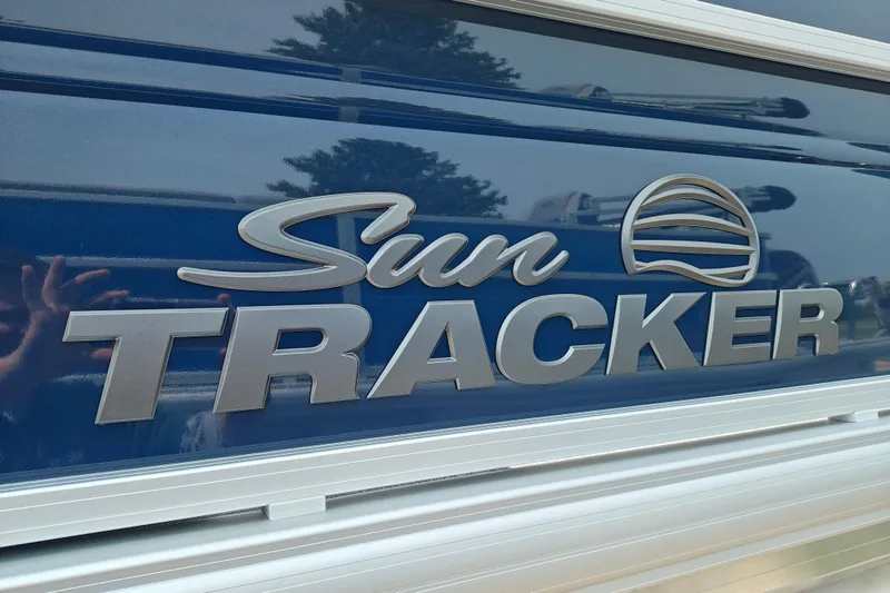 Slide: The Image of Sun Tracker SportFish 20 DLX 2026 logo on blue boat exterior. - 3
