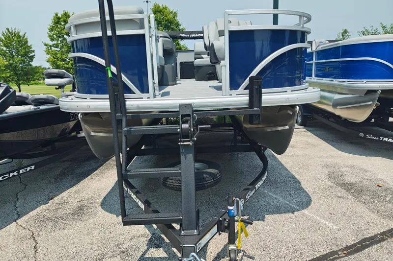Slide: The Image of 2026 Sun Tracker SportFish 20 DLX pontoon boat on trailer, parked outdoors. - 4