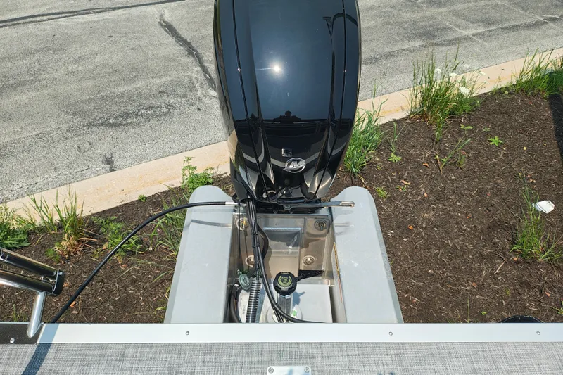Slide: The Image of 2026 Sun Tracker SportFish 20 DLX boat engine, parked on pavement with greenery. - 25