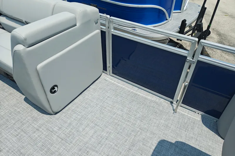 Slide: The Image of 2026 Sun Tracker SportFish 20 DLX pontoon boat interior with gray seating and blue paneling. - 11