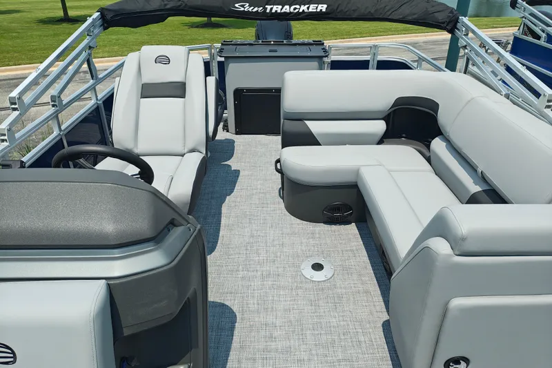 Slide: The Image of 2026 Sun Tracker SportFish 20 DLX pontoon boat interior with plush seating and steering console. - 12