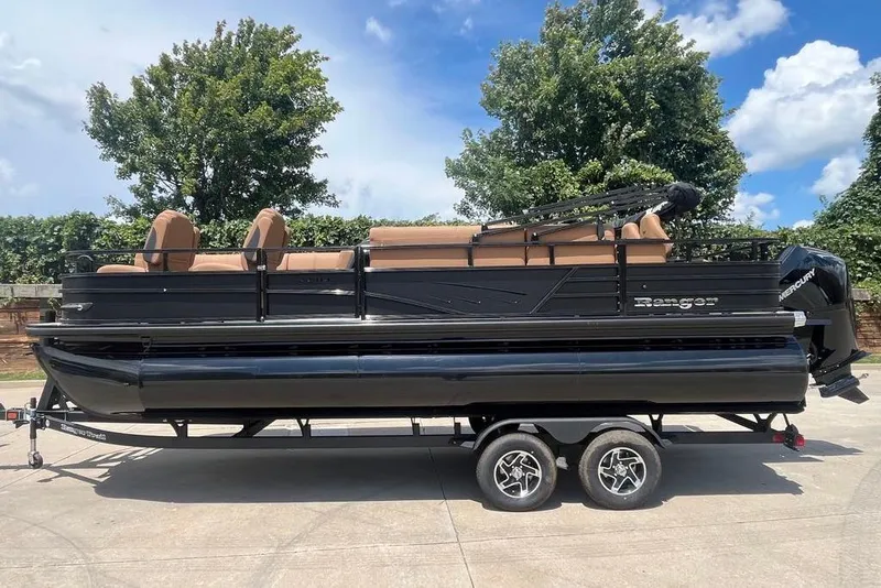 The Image of 2026 Ranger 223FC pontoon boat on trailer, parked outdoors under blue sky. - 0