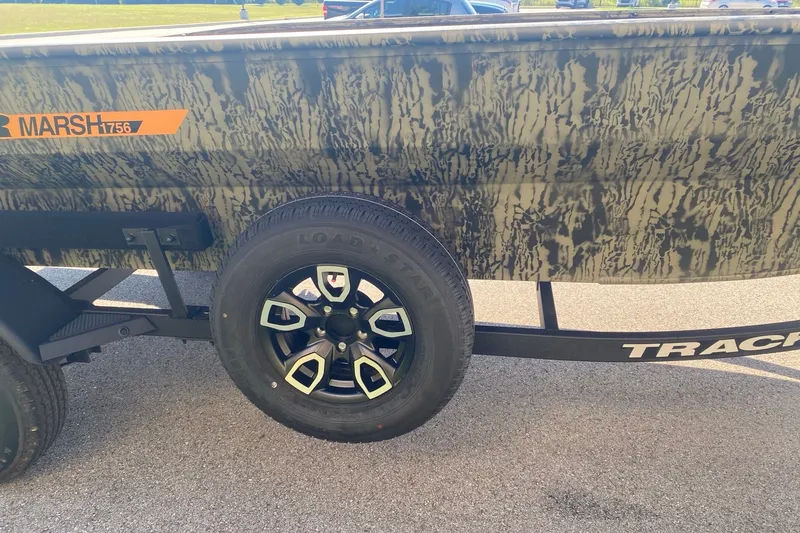 Slide: The Image of 2026 Tracker Grizzly 1756 T Marsh boat with camouflage design and trailer wheel. - 6