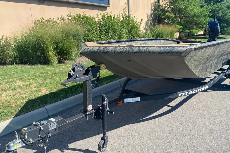 Slide: The Image of 2026 Tracker Grizzly 1756 T Marsh boat on trailer, parked outdoors. - 2