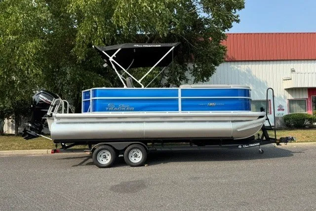 The Image of 2026 Sun Tracker Party Barge 20 DLX pontoon boat on trailer, parked outdoors. - 0