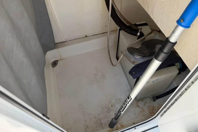 Slide: The Image of Interior storage compartment of a 2021 Sea Pro 248 Bay boat, featuring equipment and a drain. - 30