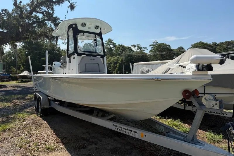 The Image of 2021 Sea Pro 248 Bay boat on trailer, parked outdoors under clear sky. - 0