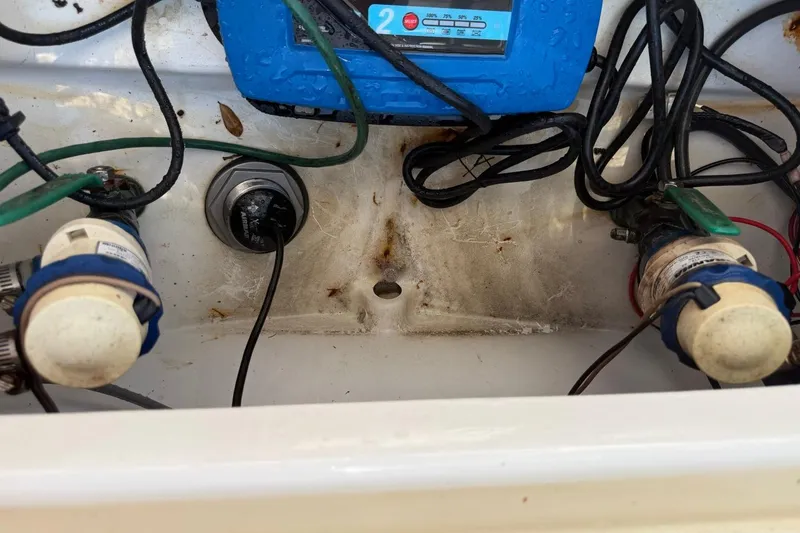 Slide: The Image of Bilge area of a 2021 Sea Pro 248 Bay boat with wiring and pumps visible. - 25
