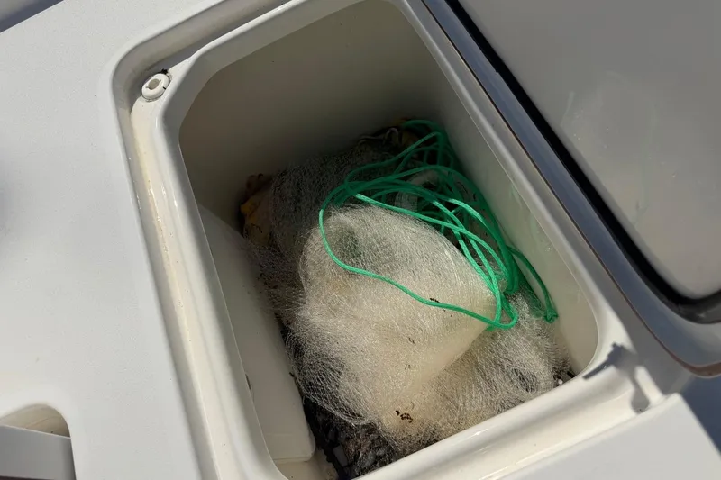 Slide: The Image of Storage compartment on a 2021 Sea Pro 248 Bay boat with fishing net inside. - 23