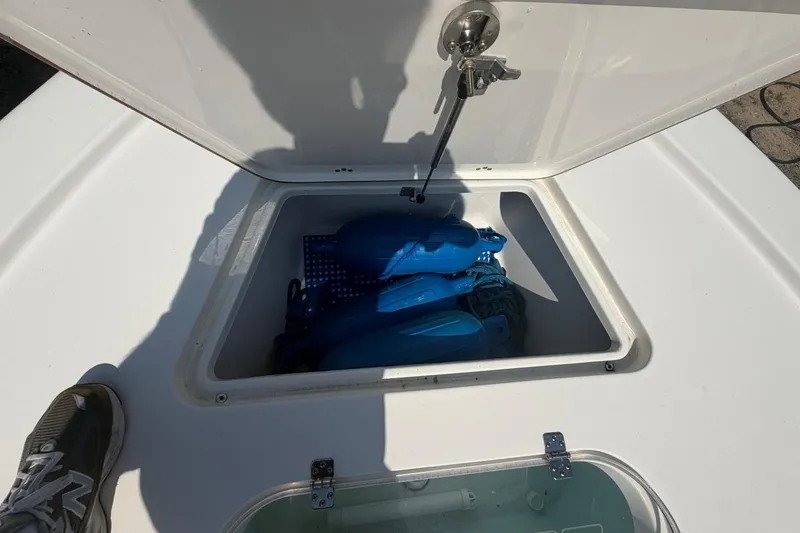 Slide: The Image of Open storage compartment on 2021 Sea Pro 248 Bay boat with blue fenders inside. - 36