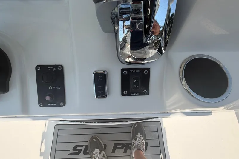 Slide: The Image of 2021 Sea Pro 248 Bay boat controls with Suzuki engine panel and cup holder. - 11