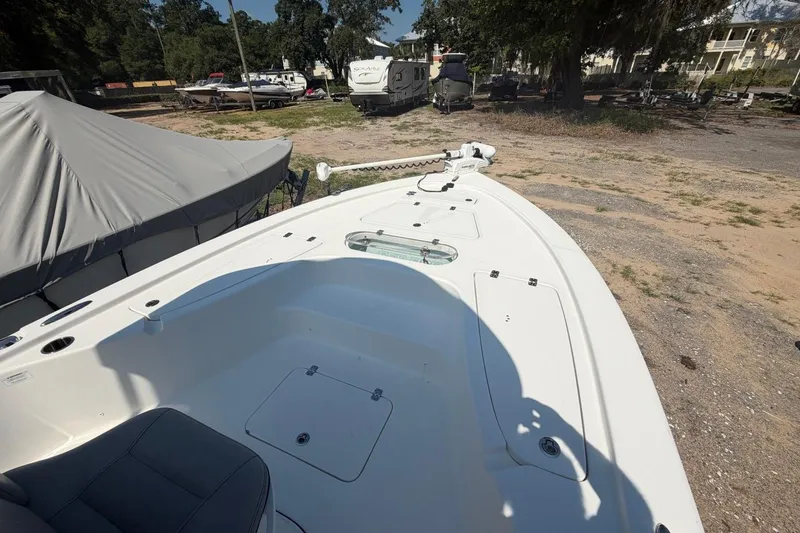 Slide: The Image of 2021 Sea Pro 248 Bay boat deck with storage compartments and seating, parked outdoors. - 41