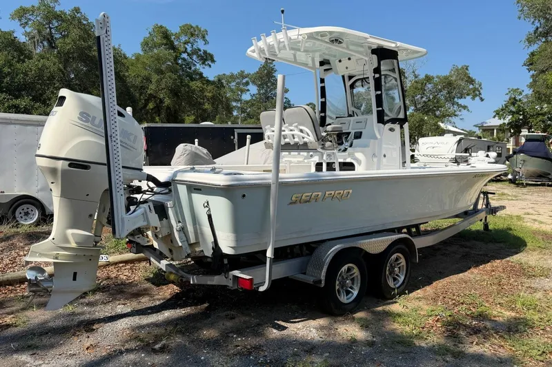 Slide: The Image of 2021 Sea Pro 248 Bay boat on trailer with Suzuki outboard motor, parked outdoors. - 4