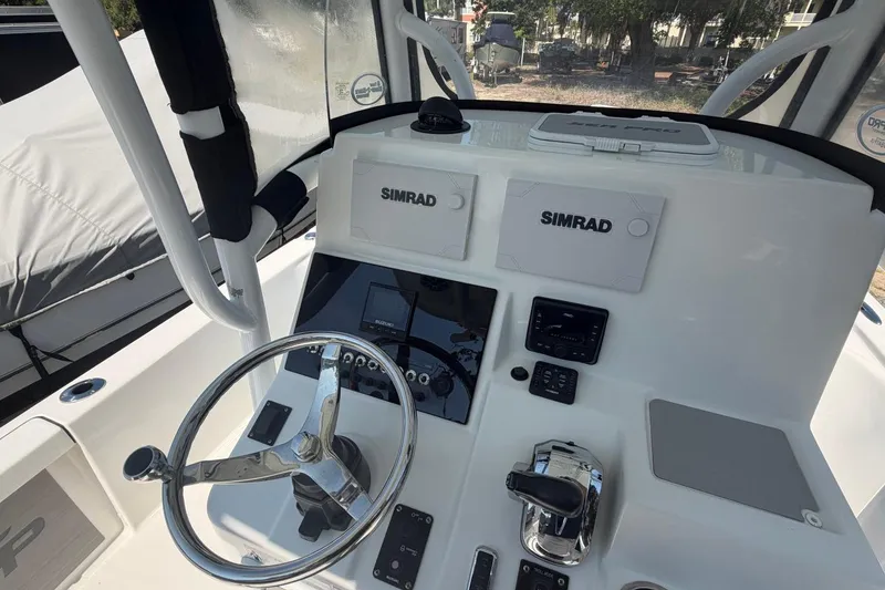 Slide: The Image of 2021 Sea Pro 248 Bay boat dashboard with Simrad electronics and steering wheel. - 7