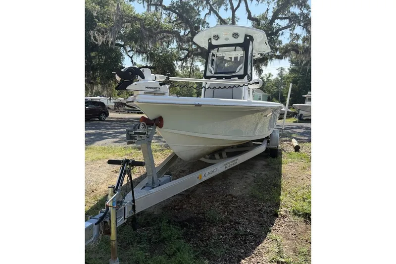 Slide: The Image of 2021 Sea Pro 248 Bay boat on trailer, parked outdoors under trees. - 1