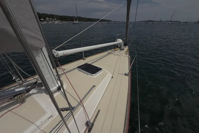 Slide: The Image of 2006 J Boats J/100 sailboat deck on calm waters, moored with other boats nearby. - 12