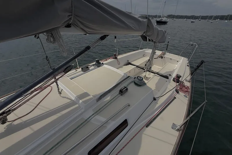 Slide: The Image of 2006 J Boats J/100 sailboat deck with rigging and covered boom on calm water. - 17