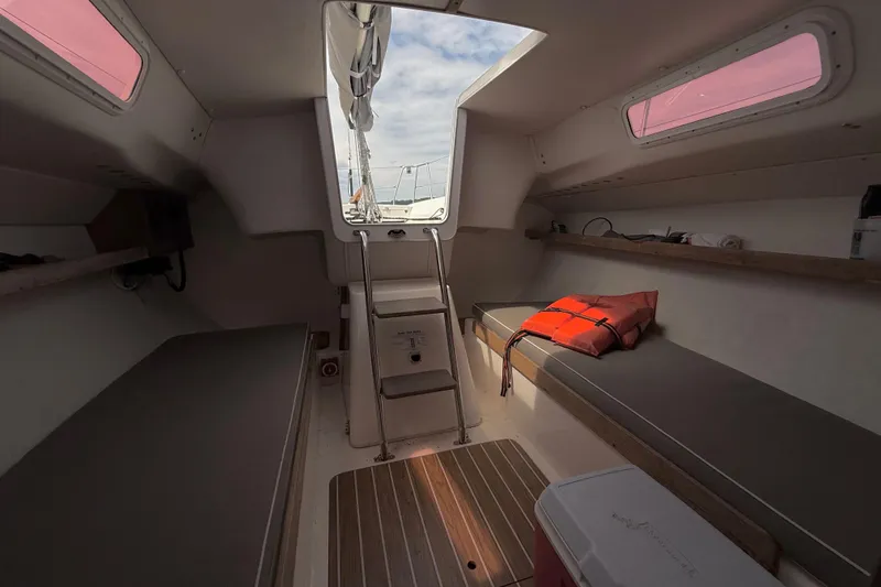 Slide: The Image of Interior of a 2006 J/100 with benches, wood accents, and a life jacket. - 25