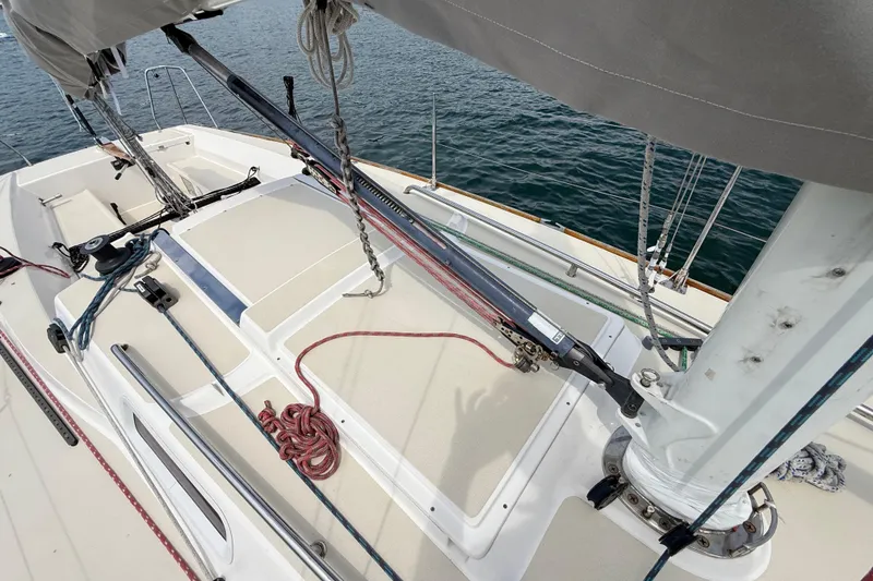 Slide: The Image of 2006 J Boats J/100 sailboat deck with rigging and ropes, docked on calm water. - 8