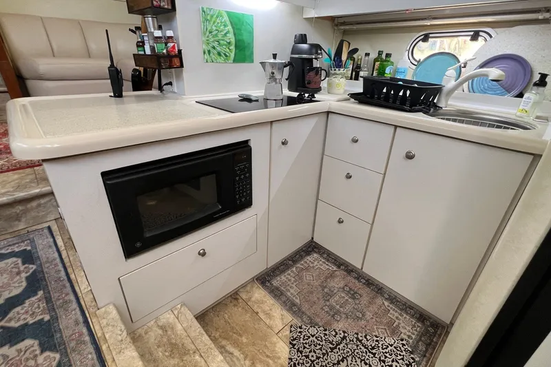 Slide: The Image of 1998 Cruisers Yachts 3650 Aft Cabin kitchen with microwave, sink, and countertop appliances. - 34