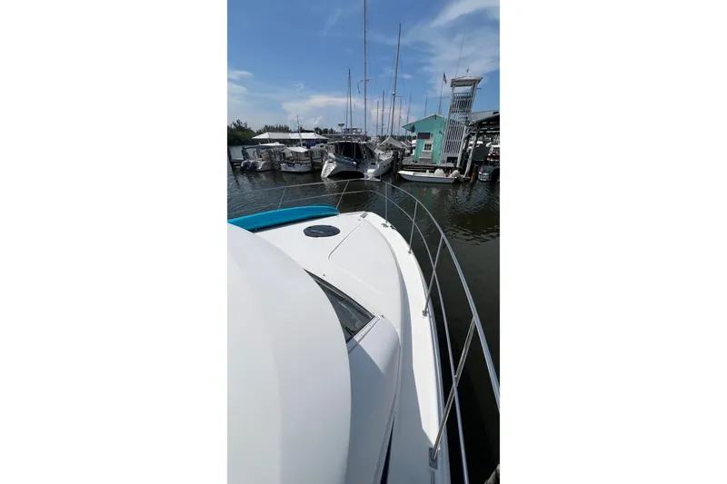 Slide: The Image of 1998 Cruisers Yachts 3650 Aft Cabin docked at marina under clear sky. - 3