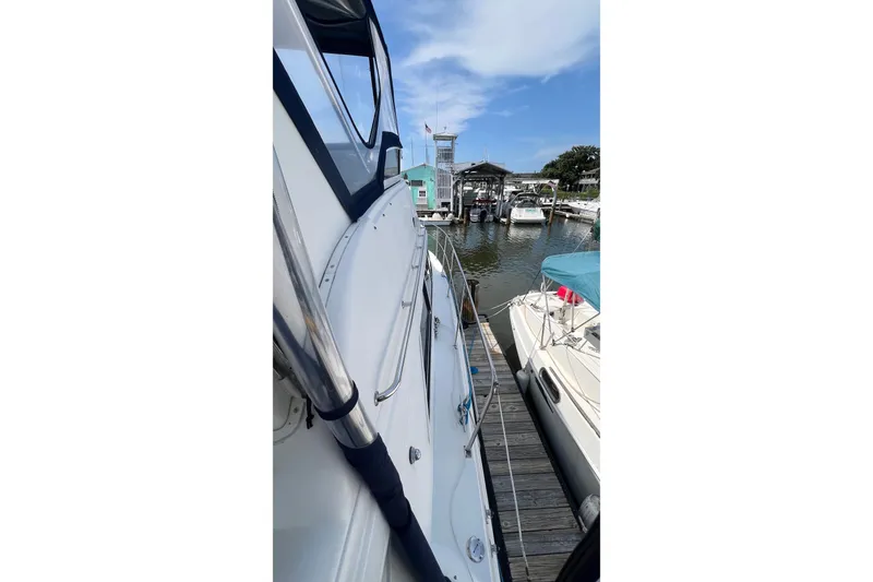 Slide: The Image of 1998 Cruisers Yachts 3650 Aft Cabin docked at marina under blue sky. - 5