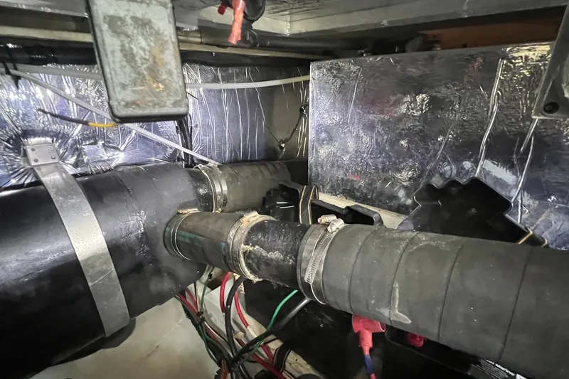 Slide: The Image of Engine room of 1998 Cruisers Yachts 3650 Aft Cabin with visible pipes and insulation. - 29