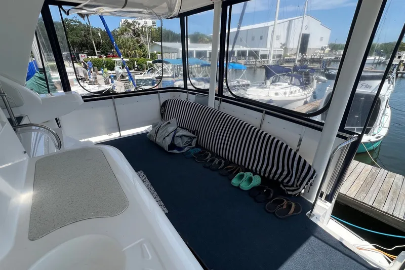 Slide: The Image of 1998 Cruisers Yachts 3650 Aft Cabin interior with striped seating, marina view, and footwear. - 16