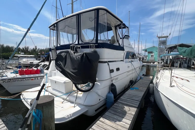 Slide: The Image of 1998 Cruisers Yachts 3650 Aft Cabin docked at marina under clear blue sky. - 6