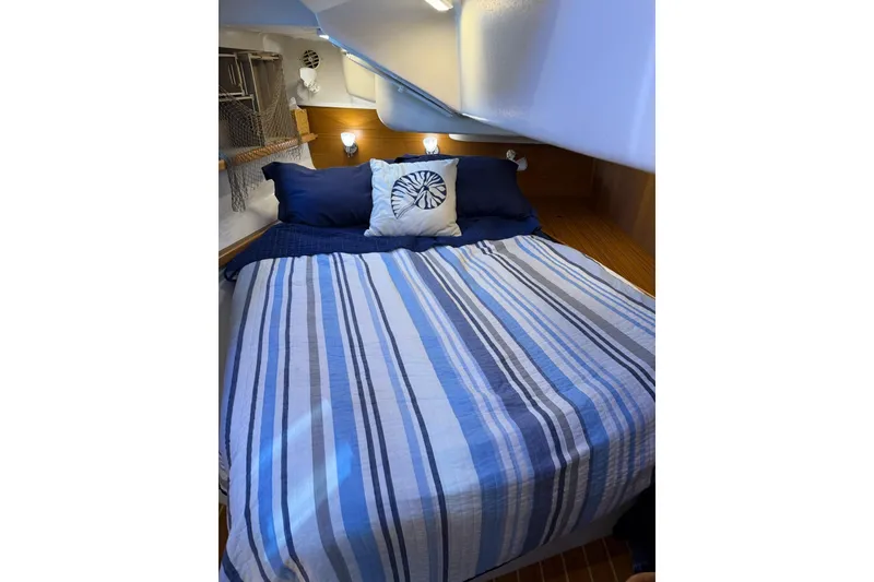 Slide: The Image of Cozy cabin bedroom in 2015 Catalina 445 sailboat with striped bedding and nautical decor. - 57