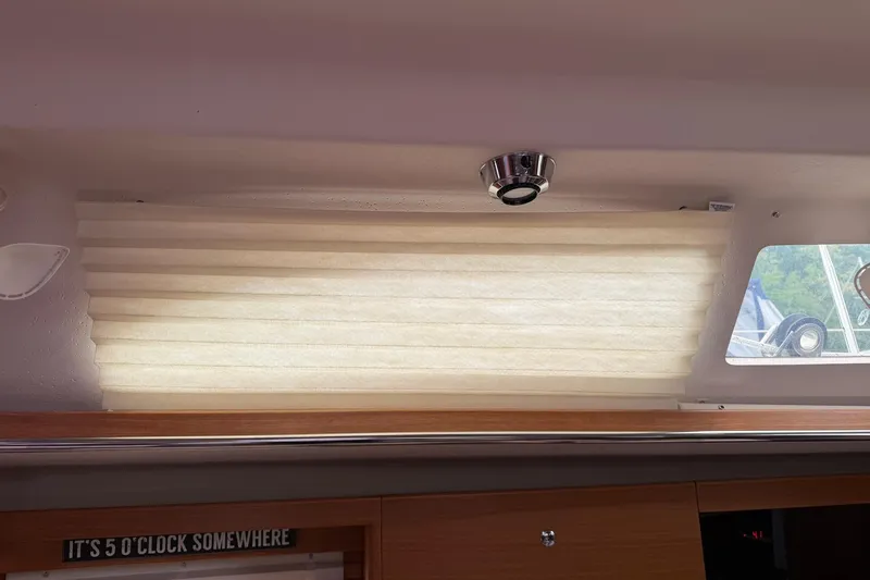 Slide: The Image of Interior of 2015 Catalina 445 yacht with window shade and "It's 5 o'clock somewhere" sign. - 35