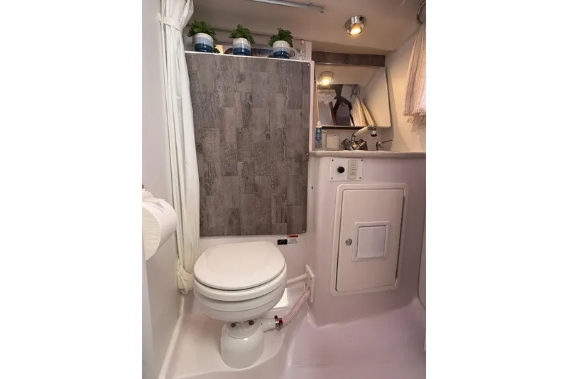 Slide: The Image of 2015 Catalina 445 yacht bathroom with toilet, sink, and wood paneling. - 48