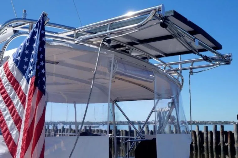 Slide: The Image of Catalina 445 sailboat (2015) with solar panels and American flag, docked by the water. - 4