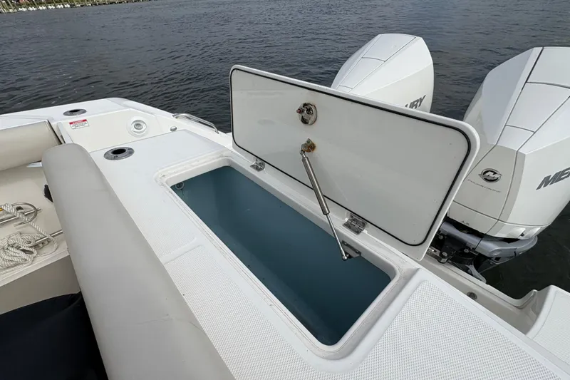 Slide: The Image of 2020 Boston Whaler 330 Outrage boat with open storage compartment and twin Mercury engines. - 23