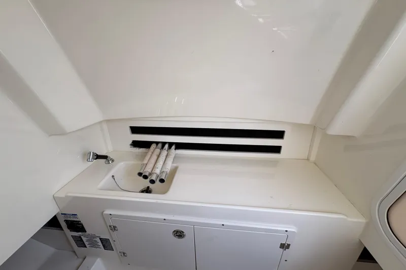 Slide: The Image of 2020 Boston Whaler 330 Outrage interior sink and storage area. - 15