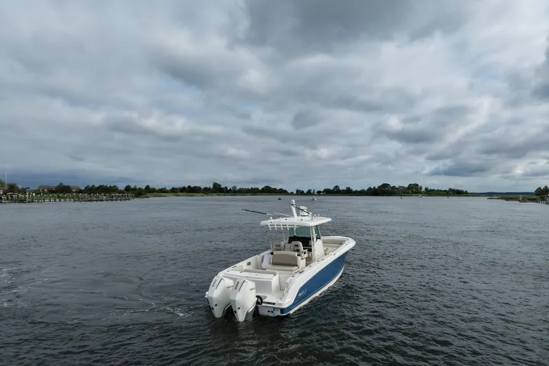 Slide: The Image of 2020 Boston Whaler 330 Outrage boat on a calm, cloudy waterway. - 5
