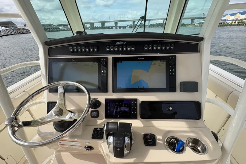 Slide: The Image of Cockpit of 2020 Boston Whaler 330 Outrage with navigation screens and steering wheel. - 8
