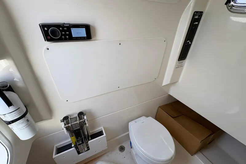 Slide: The Image of Interior of 2020 Boston Whaler 330 Outrage boat featuring a compact marine toilet. - 14