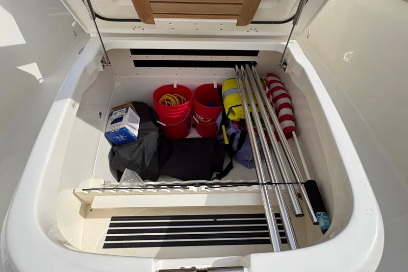 Slide: The Image of Storage compartment of a 2020 Boston Whaler 330 Outrage with boating equipment. - 25