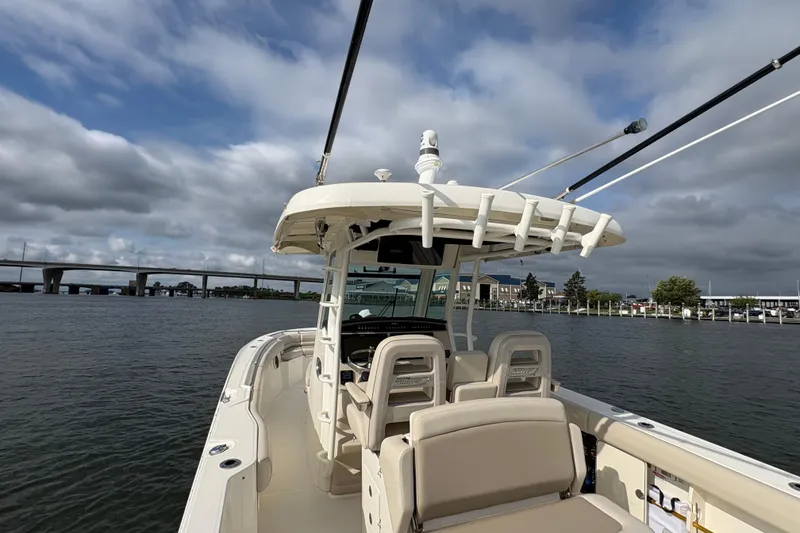 Slide: The Image of 2020 Boston Whaler 330 Outrage boat on water with bridge and cloudy sky. - 7