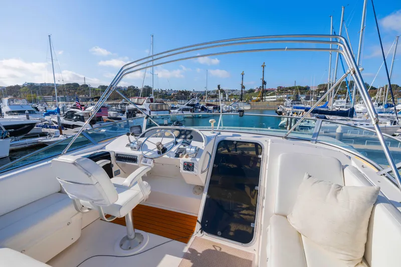 Slide: The Image of 1998 Bayliner 4788 Pilot House Motoryacht interior at marina, featuring helm and seating area. - 27
