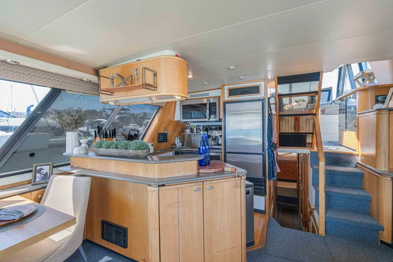 Slide: The Image of Interior of 1998 Bayliner 4788 Pilot House Motoryacht with modern kitchen and dining area. - 6