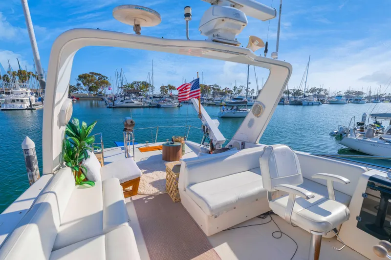 Slide: The Image of 1998 Bayliner 4788 Pilot House Motoryacht interior with seating, plants, and marina view. - 28