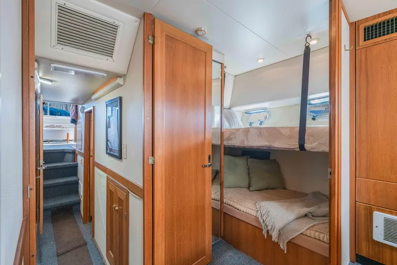 Slide: The Image of 1998 Bayliner 4788 Pilot House Motoryacht interior with cozy bunk beds and wooden cabinetry. - 16