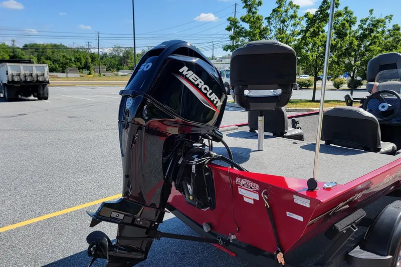 Slide: The Image of 2024 Tracker Bass Tracker Classic XL boat with Mercury outboard motor in a parking lot. - 2