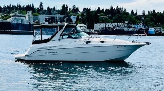 The Image of 2003 Monterey 302 Cruiser boat on calm water with marina background. - 0