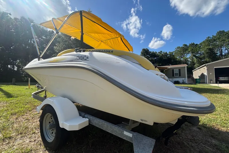 Slide: The Image of 2004 Sea-Doo Sportster LE DI boat with yellow canopy on trailer, parked outdoors. - 6