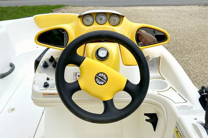 Slide: The Image of 2004 Sea-Doo Sportster LE DI dashboard with yellow accents and steering wheel. - 6